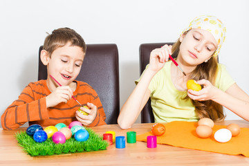 Naklejka premium Two kids painting easter eggs