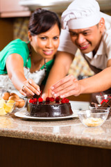Asian couple baking chocolate cake in kitchen