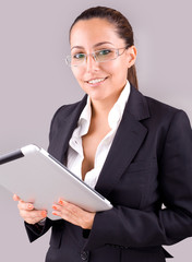 Young smiling business woman with tablet computer on grey backgr