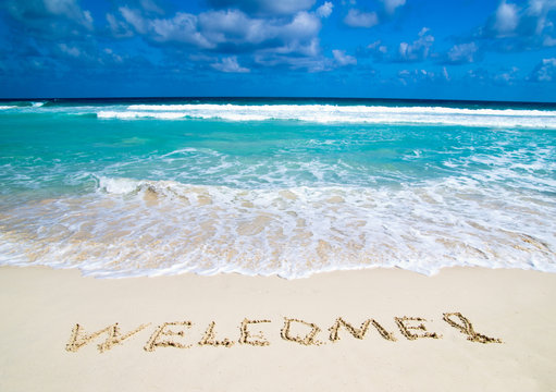 welcome written in beach