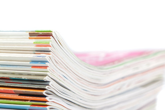 A stack of magazines on a white background. Close-up.