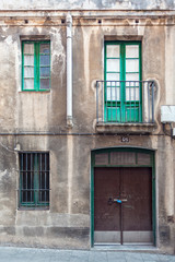 Facade with metal door, windows and balcony