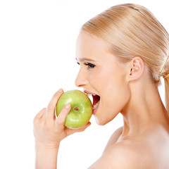 Side view of blond woman  she bites an apple