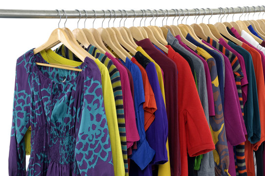 casual clothes of different colors on hangers