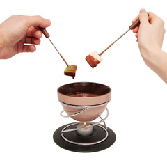 Chocolate fondue. Two hands, male and female, with fruit.