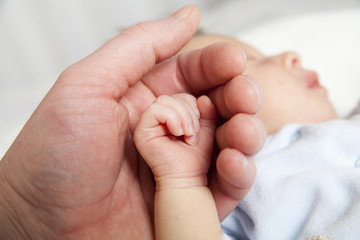 hold a hand of the newborn child