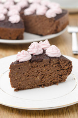 piece of chocolate cake with nuts on a plate vertical