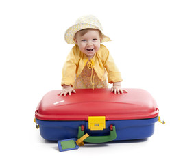 laughing baby with red and blue suitcase, on white