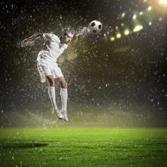 Foto op Plexiglas Voetbal voetballer die de bal slaat