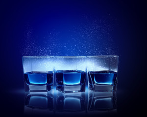 Three glasses of blue liquid