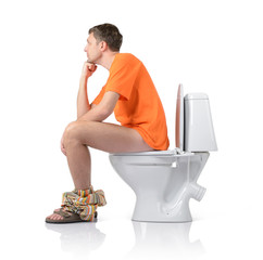 Thoughtful man sitting on the toilet, white background