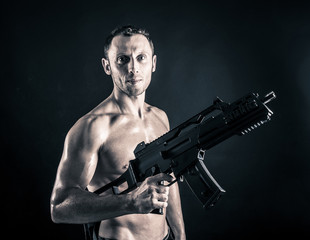 Fototapeta na wymiar Przekonana, młody człowiek shirtless portret z pistoletu maszynowego