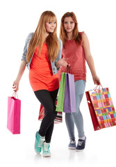 Two girls with shopping bags. Isolated over white background.