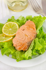 salmon with lemon on lettuce with glass of wine