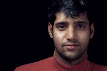 Obraz premium Portrait of young Indian man over dark