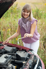 Fototapeta na wymiar kobieta próbuje naprawić samochód