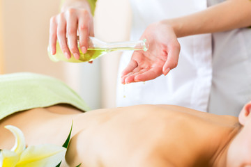 woman having wellness back massage in spa