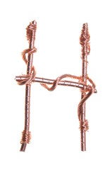 Obraz premium Twisted copper wire in the shape of the letter H