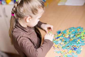 Cute little girl solving puzzles