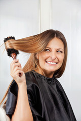 Fototapeta premium Woman Brushing Hair In Salon
