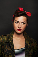 Fototapeta premium Pin-up woman with milytary jacket om black background