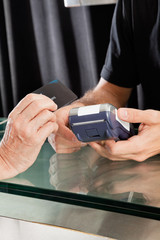 Female Customer Paying Through Credit Card To Hairstylist