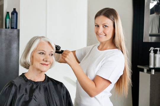 Hairdresser Ironing Customer's Hair