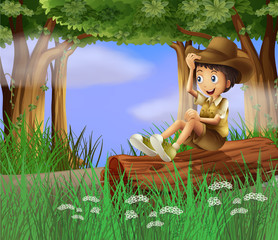 Un jeune garçon avec un chapeau assis au tronc