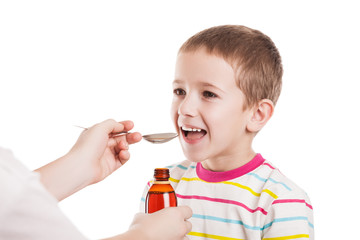 Doctor giving spoon of syrup to child boy