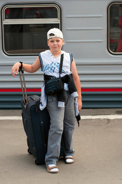 Boy with travel bag near the train