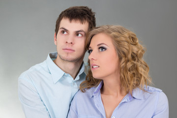 portrait of young happy couple over grey
