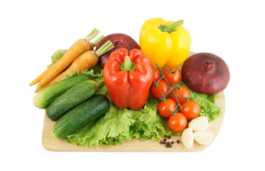 Vegetables on wooden cutting board isolated on white