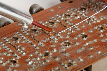 soldering iron in his hand on a white
