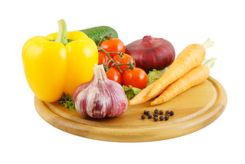 Vegetables on wooden cutting board isolated on white