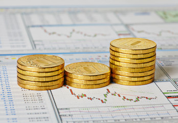 Financial settlement with the charts and golden coins. Selective