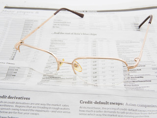 Glasses on the stock market index page of a newspaper