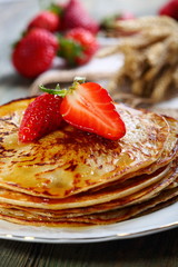 Pancakes with honey and strawberries.