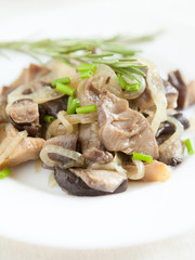 oyster mushrooms and onions on a white dish