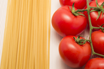 spaghetti and tomatoes on a table ready to cook