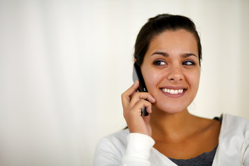 Young woman speaking on cellphone looking right