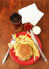 Tasty cheeseburger with fried potatoes and cold drink,