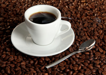 Cup of coffee on coffee beans background