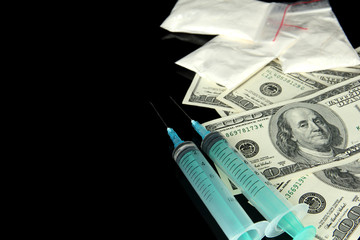 Drugs, money and syringes, isolated on black