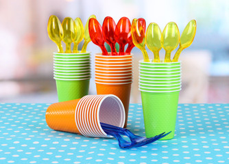Cups, spoons and forks, of different colors on bright