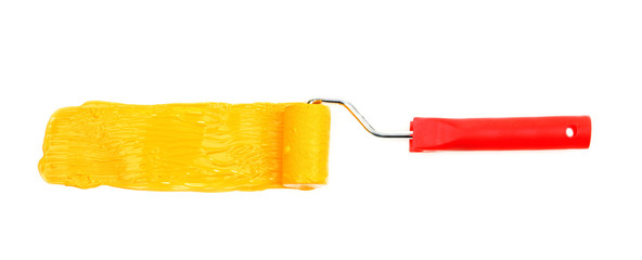 Roller brush with yellow paint isolated on white