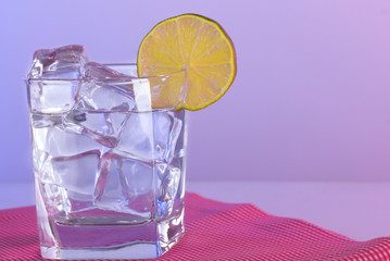 Ice in a glass on a color background