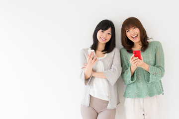 attractive asian women using smart phone in the room