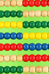 Bright wooden toy abacus, on green background