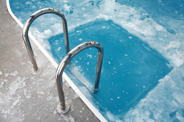 Ice swimming theme. Steps in the frozen blue pool ice-hole