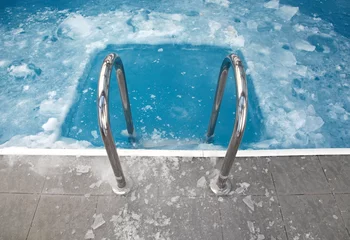 Rolgordijnen Steps in the frozen blue pool ice-hole © evannovostro